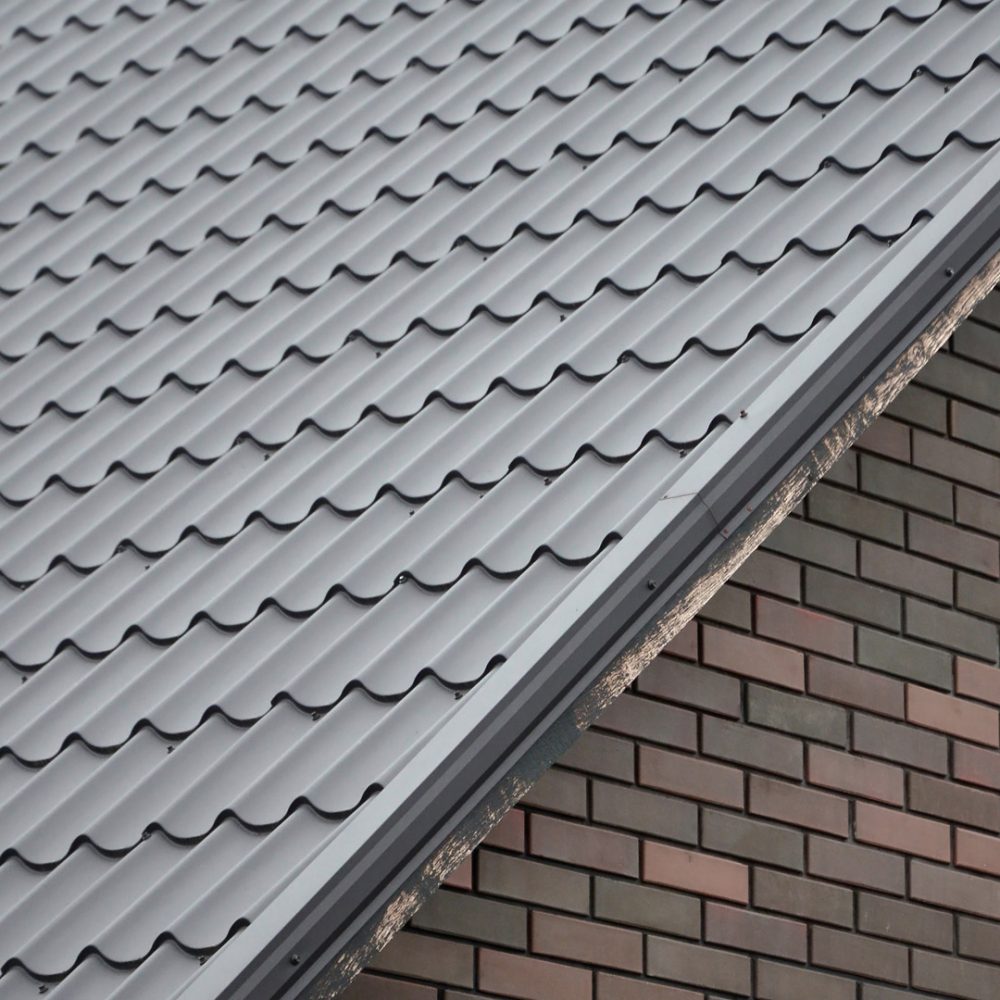 Modern brown roof made of painted metal. Corrugated metal roof and metal roofing industry concept
