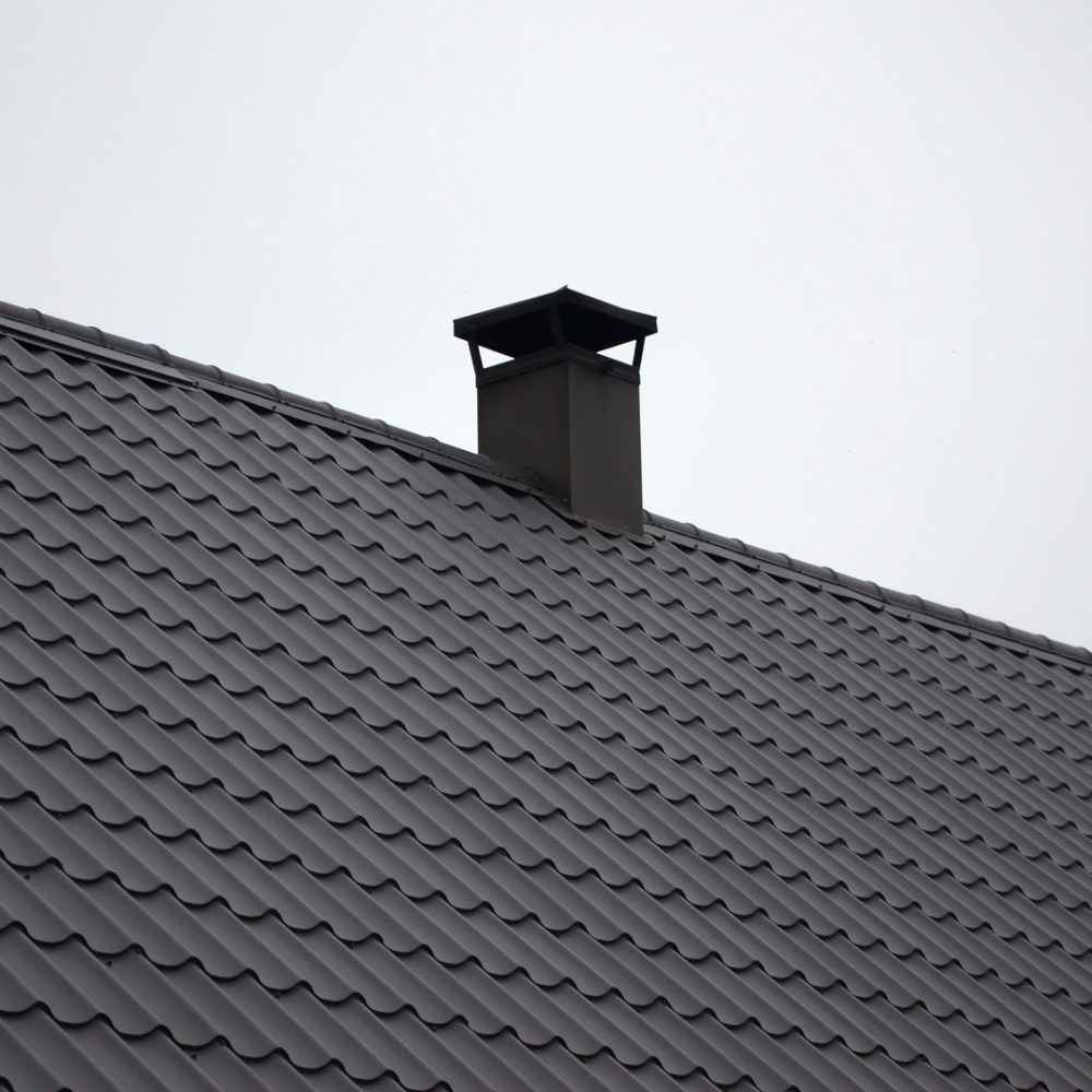 Modern brown roof made of painted metal. Corrugated metal roof and metal roofing industry concept